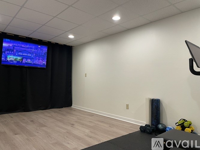 A room with a television screen showing a map and some exercise equipment.
