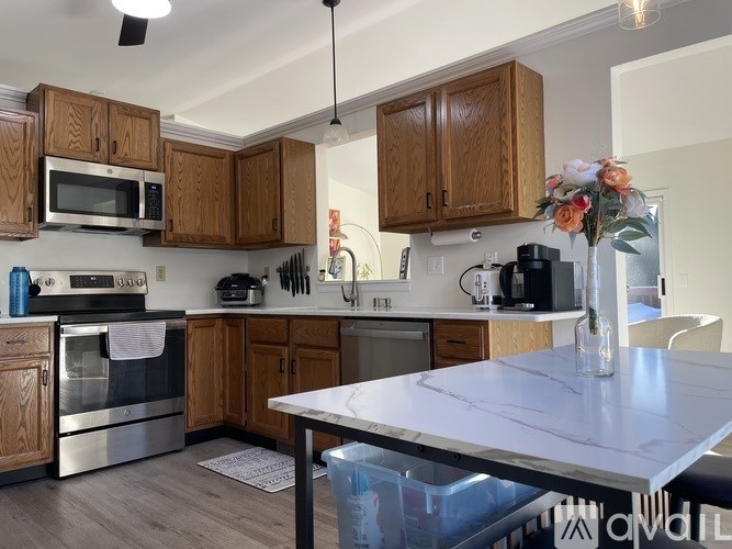 A kitchen with wooden cabinets and a marble countertop.