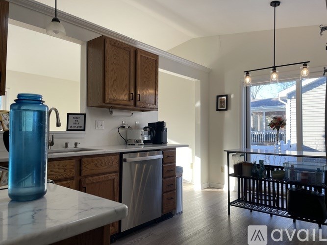 A kitchen with wooden cabinets and a blue jar on the counter.