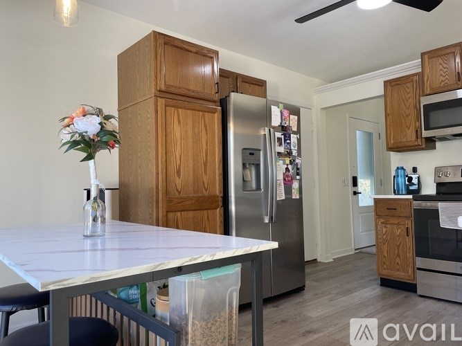 A kitchen with a table, chairs, and a refrigerator.