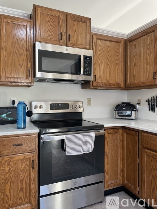 A kitchen with wooden cabinets and a stainless steel oven.