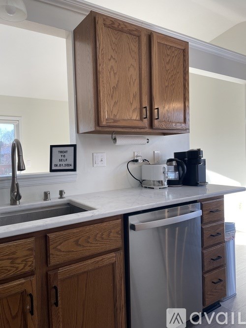 A kitchen with wooden cabinets and a sign that says "Treat yourself".