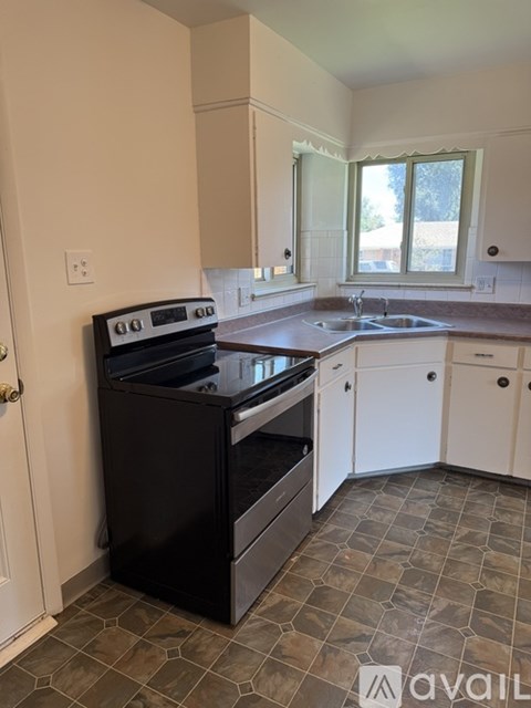 A kitchen with a black oven and white cabinets.