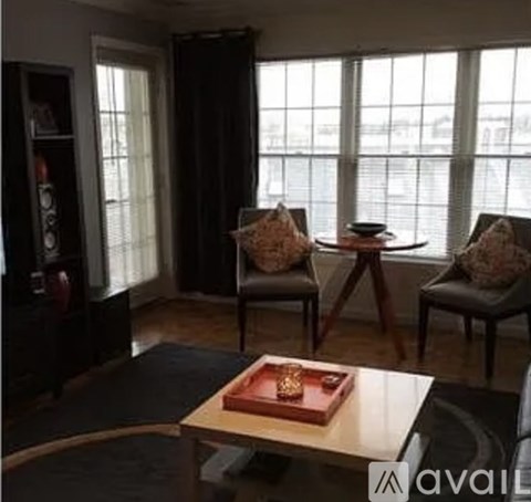 A living room with a table, two chairs and a book on it.