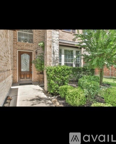 A house with a brown door and a small garden in front.
