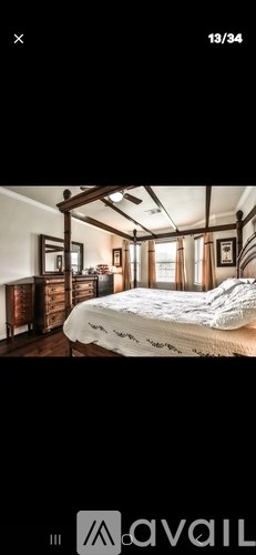 A bedroom with a bed, dresser, and mirror.