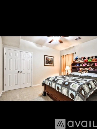 A bedroom with a bed, a dresser, and a ceiling fan.
