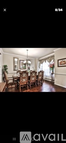A dining room with a wooden table and chairs.