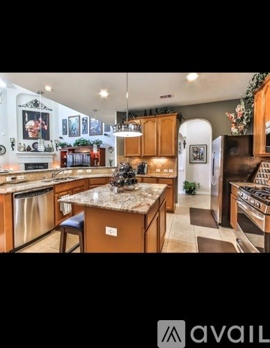 A kitchen with a granite countertop and wooden cabinets.