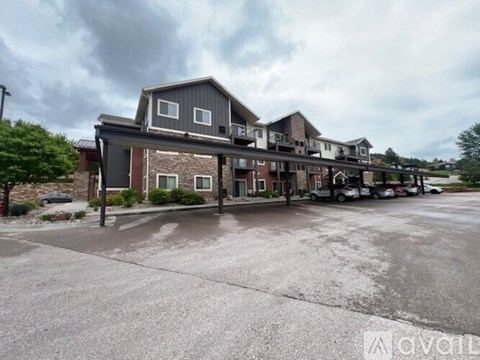 A row of houses with a parking lot in front.