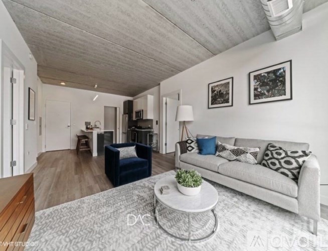 A living room with a grey couch and a coffee table in the middle.