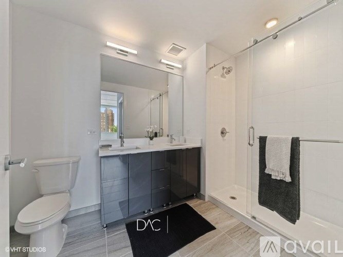 A bathroom with a toilet, sink, and shower.