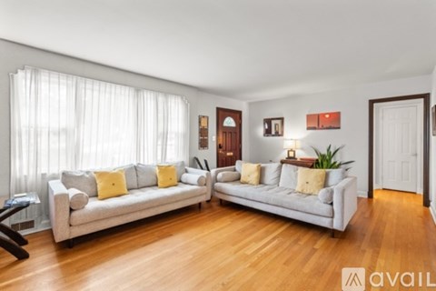 A living room with a white couch and a wooden floor.