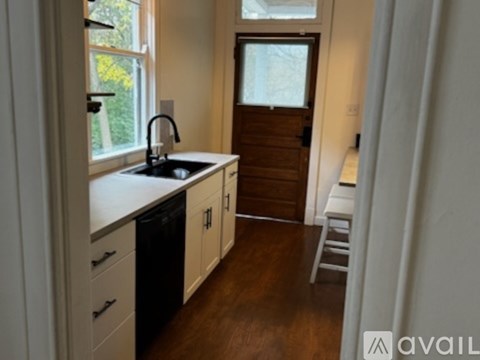 A kitchen with white cabinets and a black sink.