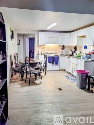 A kitchen with white cabinets and a wooden floor.