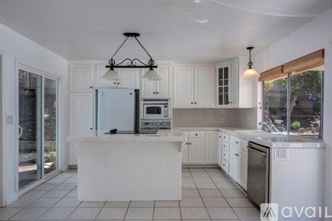 A kitchen with white cabinets and a large island.