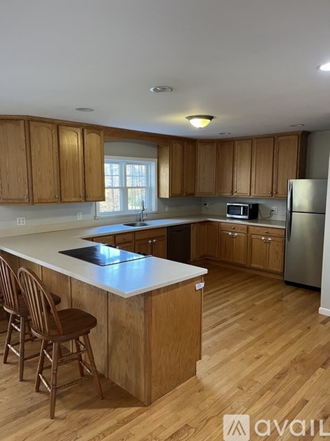 A kitchen with wooden cabinets and a white island.