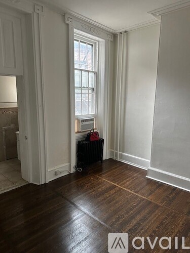 A room with a wooden floor and a window.