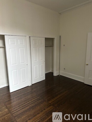 A room with white doors and wooden floors.
