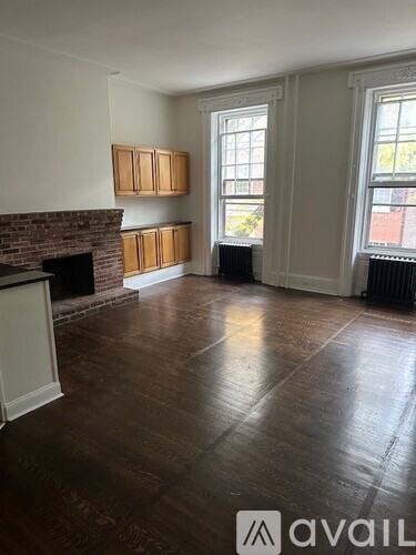 A room with a fireplace and wood flooring.