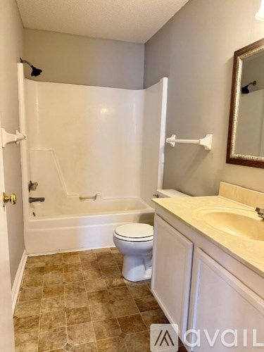 A bathroom with a toilet, sink, and shower.