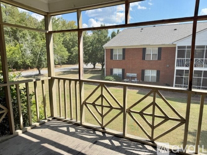 A sunny day at a house with a wooden deck.
