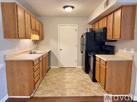 A kitchen with wooden cabinets and black appliances.