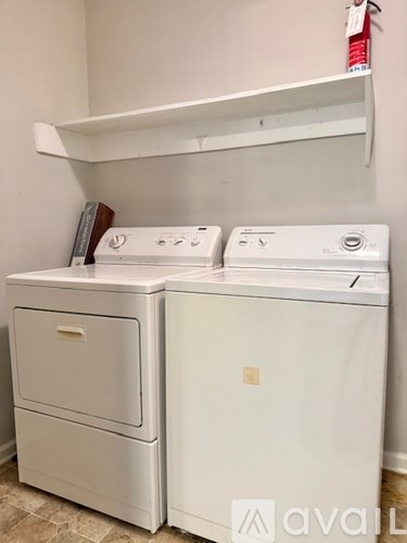 Two white front loading washing machines in a laundry room.