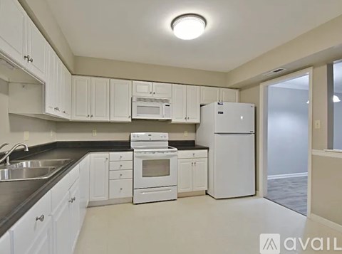 A kitchen with white cabinets and appliances.
