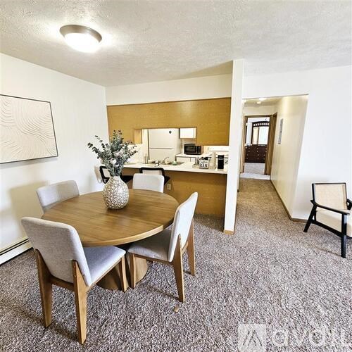 A dining room with a round table and chairs.