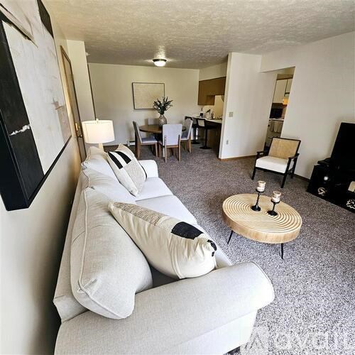 A living room with a grey couch and a wooden coffee table.