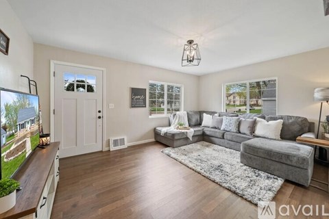 A living room with a grey couch and a white door.