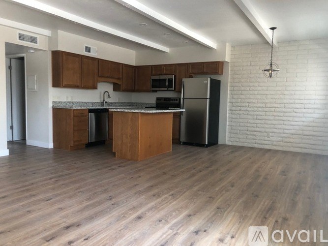 A kitchen with wooden cabinets and a brick wall.