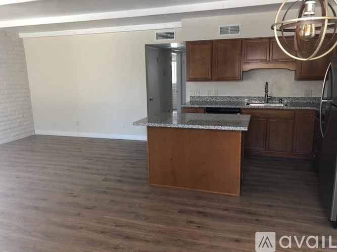A kitchen with wooden cabinets and a granite countertop.