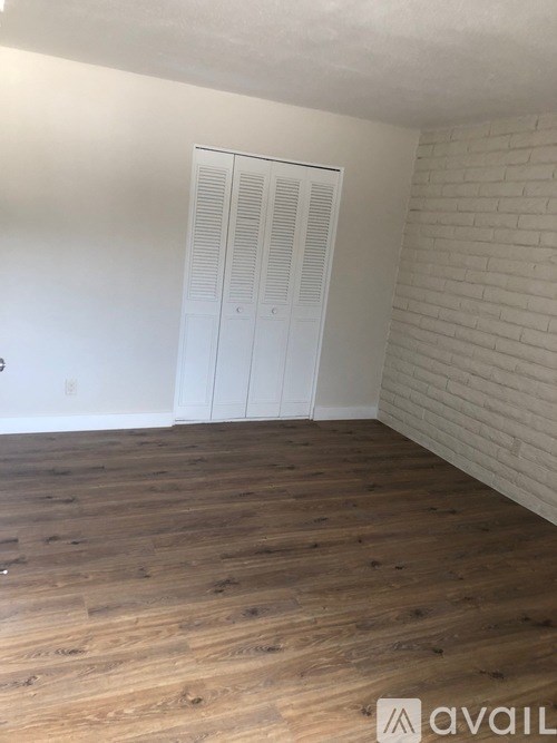 A room with wooden flooring and a white closet.