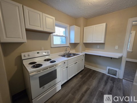 A kitchen with white appliances and cabinets.