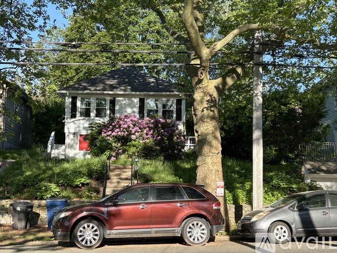 A red car is parked on the side of a street.