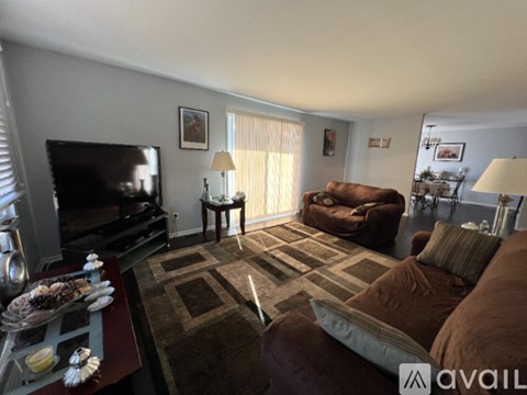 A living room with a brown couch and a television.