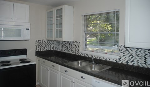 A kitchen with black and white appliances and cabinets.