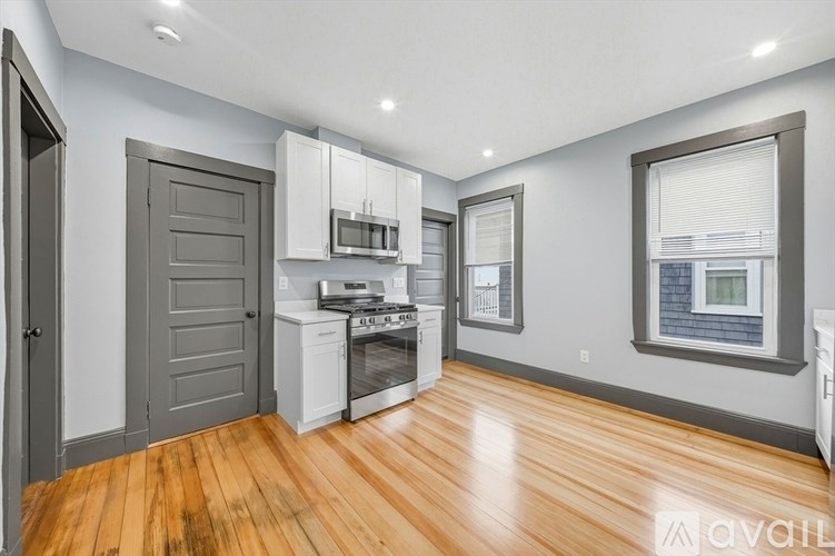A kitchen with wooden floors and white appliances.