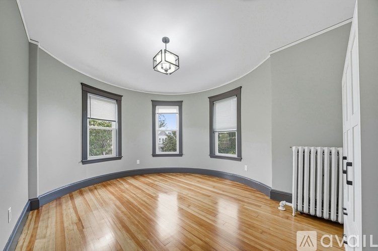 A room with wooden floors and a white ceiling with a chandelier.