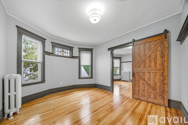 A room with wooden floors and a large wooden door.