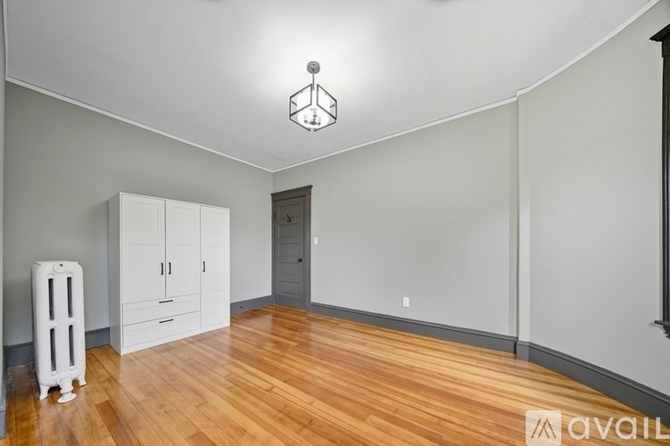 A room with wooden floors and a white radiator.