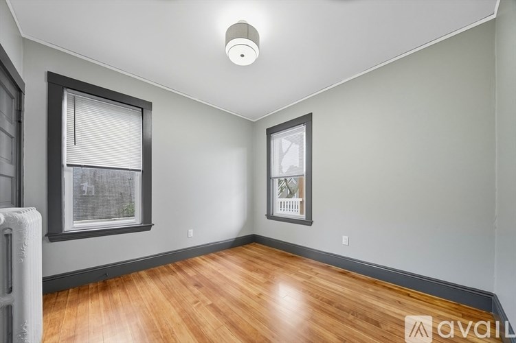 A room with wooden floors and a window with blinds.