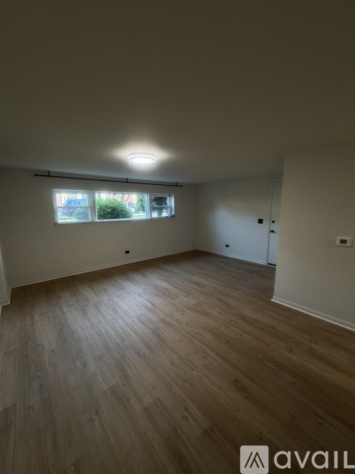 A room with a white door and a wooden floor.