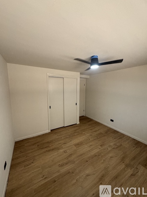 A room with wooden flooring and a ceiling fan.
