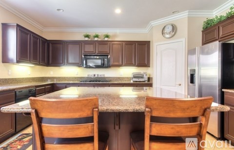 A kitchen with brown cabinets and a granite countertop.