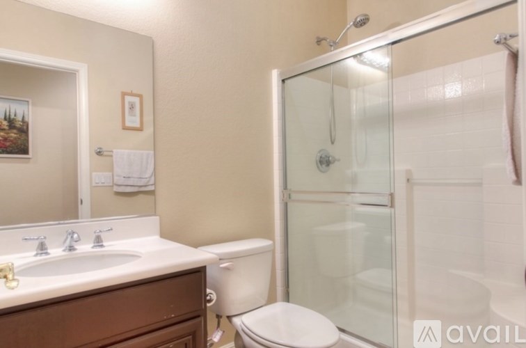 A bathroom with a glass shower door and a white toilet.