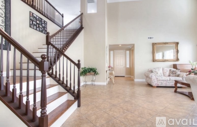 A living room with a couch, a chair, and a staircase.