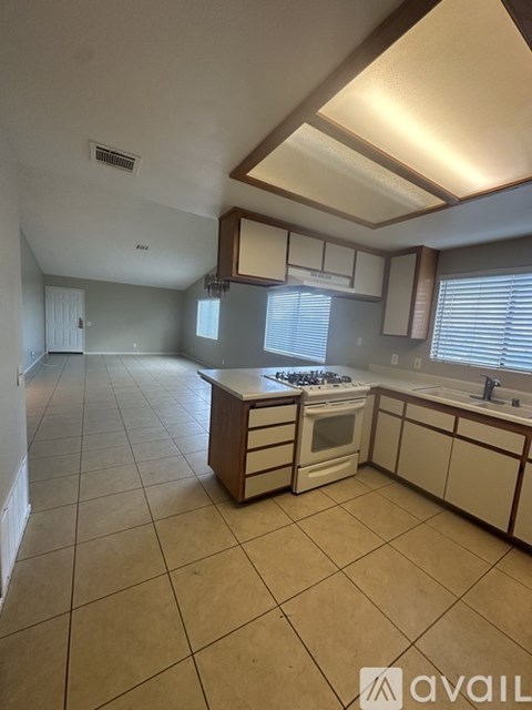 A kitchen with white cabinets and a tiled floor.